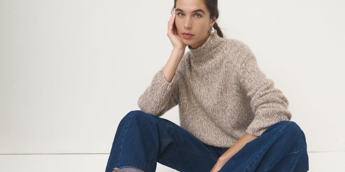 Modell trägt einen beigen Kaschmir-Cardigan von ESISTO